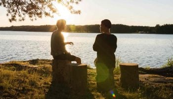 people talking near a lake